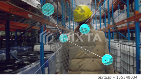 Walking inspector wearing yellow hard hat scanning barrels in narrow aisle, with cyan overlay Walking inspector wearing yellow hard hat scanning barrels in narrow aisle, with cyan overlay 135549034