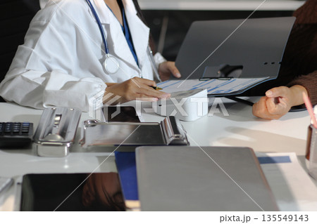 A doctor's hands carefully taking a patient's blood pressure using a sphygmomanometer. 135549143