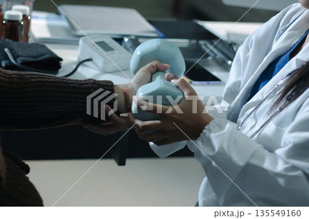 doctor is checking for muscle injuries and using dumbbells test injury and also help with physical therapy strengthen muscles because physical therapy will help strengthen muscles and help blood flow doctor is checking for muscle injuries and using dumbbells test injury and also help with physical therapy strengthen muscles because physical therapy will help strengthen muscles and help blood flow 135549160