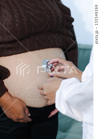 cropped shot of doctor examining pregnant woman during medical consultation cropped shot of doctor examining pregnant woman during medical consultation 135549169