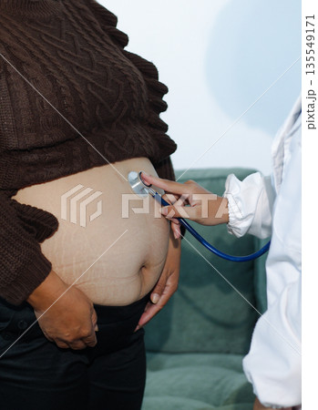 cropped shot of doctor examining pregnant woman during medical consultation cropped shot of doctor examining pregnant woman during medical consultation 135549171