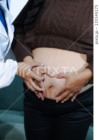 cropped shot of doctor examining pregnant woman during medical consultation cropped shot of doctor examining pregnant woman during medical consultation 135549175