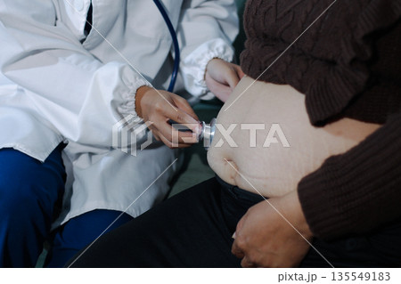 cropped shot of doctor examining pregnant woman during medical consultation cropped shot of doctor examining pregnant woman during medical consultation 135549183