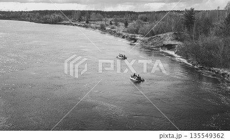 Men Dressed As US American Soldiers Of USA Infantry Of World War II carry out rafting on rubber boats In spring Autumn Day. Group of Soldiers people are preparing to disembark. Aerial view elevated 135549362