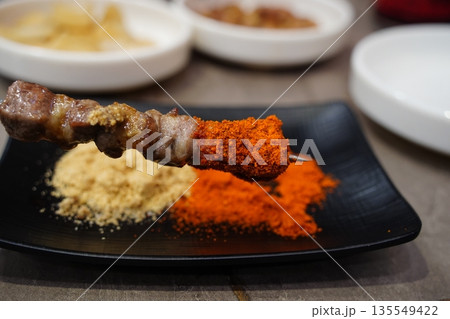 Juicy grilled lamb skewer with cumin and chili spices, a popular Chinese street food Juicy grilled lamb skewer with cumin and chili spices, a popular Chinese street food 135549422