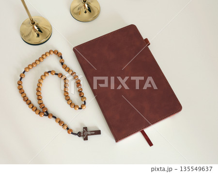 Catholic corner at home. Wooden rosary beads, cross, and prayer book. Faith, symbols, and traditions. Catholic corner at home. Wooden rosary beads, cross, and prayer book. Faith, symbols, and traditions. 135549637