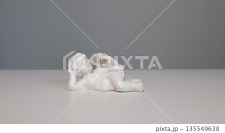 White ceramic angel figurine on white background for design. Faith, symbols, and traditions. 135549638