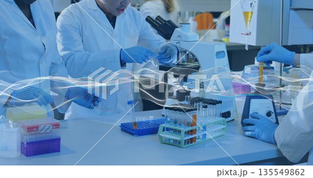 Pipetting researcher wearing lab coat and gloves, handling micropipette and test tubes at lab bench Pipetting researcher wearing lab coat and gloves, handling micropipette and test tubes at lab bench 135549862