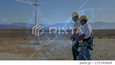 Walking two technicians in yellow safety gear crossing wind farm, DNA helix overlay, copy space 135549884