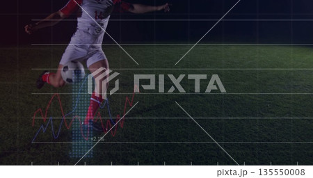 Kicking uniformed soccer player striking ball on pitch at night, with grid overlay, copy space 135550008