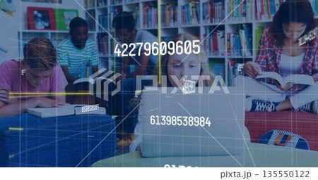 Studying group of five students typing and reading in library area, with laptop and open books 135550122