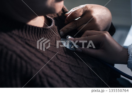 A physician uses a stethoscope to examine a patient's heart during a clinic appointment. A physician uses a stethoscope to examine a patient's heart during a clinic appointment. 135550764