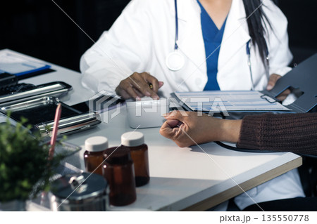 A doctor's hands carefully taking a patient's blood pressure using a sphygmomanometer. 135550778