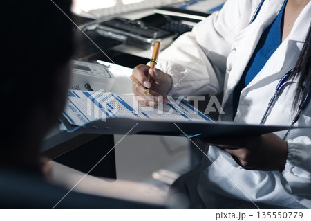 A doctor's hands carefully taking a patient's blood pressure using a sphygmomanometer. 135550779