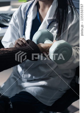 doctor is checking for muscle injuries and using dumbbells test injury and also help with physical therapy strengthen muscles because physical therapy will help strengthen muscles and help blood flow doctor is checking for muscle injuries and using dumbbells test injury and also help with physical therapy strengthen muscles because physical therapy will help strengthen muscles and help blood flow 135550787