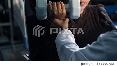 doctor is checking for muscle injuries and using dumbbells test injury and also help with physical therapy strengthen muscles because physical therapy will help strengthen muscles and help blood flow 135550788