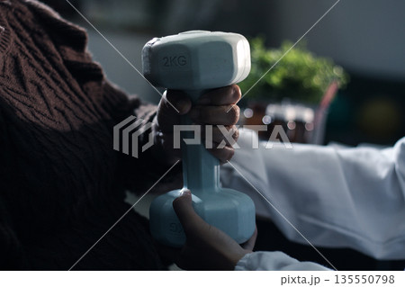 doctor is checking for muscle injuries and using dumbbells test injury and also help with physical therapy strengthen muscles because physical therapy will help strengthen muscles and help blood flow 135550798
