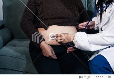 cropped shot of doctor examining pregnant woman during medical consultation cropped shot of doctor examining pregnant woman during medical consultation 135550816