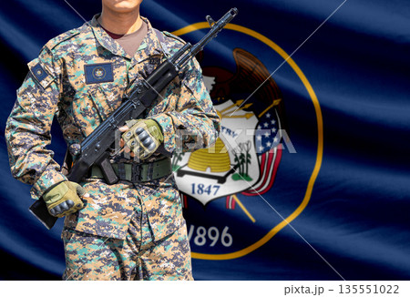 Utah US state flag with soldier holding assault rifle 135551022