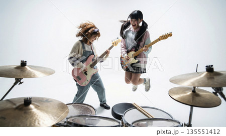 演奏しながら元気にジャンプするガールズバンドのギターボーカルとメンバー 135551412