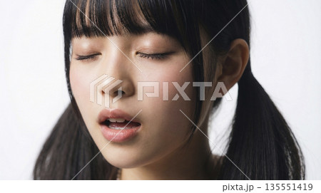 歌っている最中の表情豊かなツインテールの日本人女性の顔のクローズアップ 歌っている最中の表情豊かなツインテールの日本人女性の顔のクローズアップ 135551419