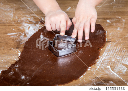 Child Cutting Gingerbread Dough With Metal Cookie Cutter On Wooden Surface 135551588