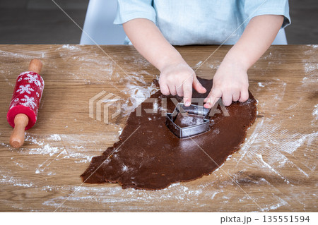 Child Cutting Gingerbread Dough With Metal Cookie Cutter On Floured Wooden Table 135551594