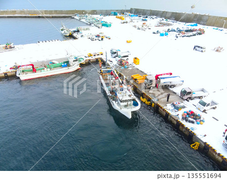 冬の北海道八雲町落部漁港を出入港する漁船の風景を空撮 冬の北海道八雲町落部漁港を出入港する漁船の風景を空撮 135551694