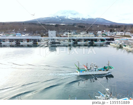 冬の北海道森町砂原漁港で出入港する漁船の風景を空撮 135551889