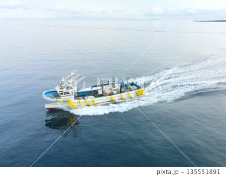 冬の北海道森町砂原漁港で出入港する漁船の風景を空撮 135551891