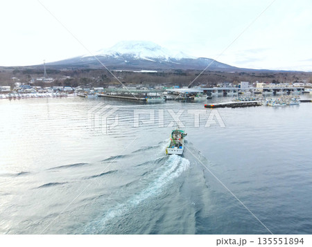 冬の北海道森町砂原漁港で出入港する漁船の風景を空撮 冬の北海道森町砂原漁港で出入港する漁船の風景を空撮 135551894