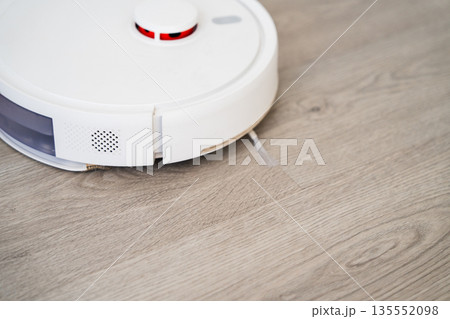 Modern robot vacuum cleaner on wooden flooring, smart domestic cleaning device and home automation technology Modern robot vacuum cleaner on wooden flooring, smart domestic cleaning device and home automation technology 135552098