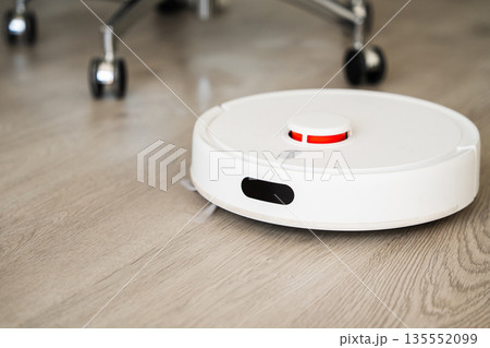 Robotic vacuum cleaner cleaning wooden floor in modern smart home interior, automated household robot technology Robotic vacuum cleaner cleaning wooden floor in modern smart home interior, automated household robot technology 135552099