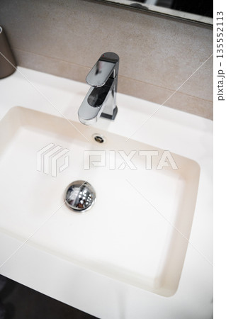Modern bathroom sink with chrome faucet and white basin, minimalist interior design detail, clean hygiene concept with copy space Modern bathroom sink with chrome faucet and white basin, minimalist interior design detail, clean hygiene concept with copy space 135552113