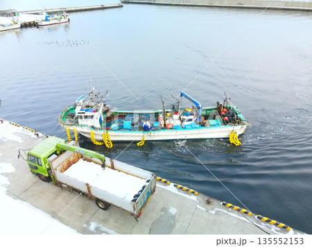 冬の北海道森町石倉漁港で入港する漁船の風景を空撮 135552153
