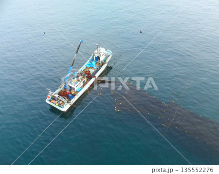 冬の北海道森町沖で定置網漁をする漁船の風景を空撮 135552276