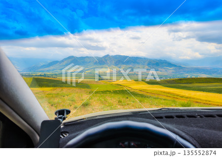 rural landscape behind car windshield, drivers perspective 135552874