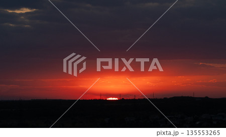 Fiery Red Sunset Over Distant City Horizon 135553265