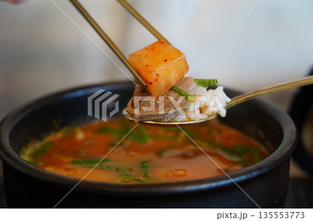 Delicious Korean Sundaegukbap (blood sausage rice and soup) served in a steaming earthenware pot with radish kimchi (Kkakdugi). Delicious Korean Sundaegukbap (blood sausage rice and soup) served in a steaming earthenware pot with radish kimchi (Kkakdugi). 135553773