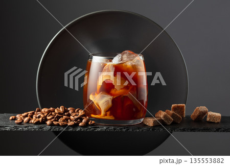 Iced coffee with cream on a black background. 135553882