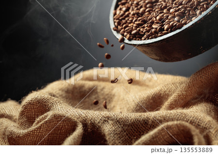 Freshly roasted coffee beans are poured into a bag. 135553889