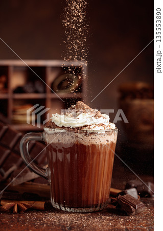 Hot chocolate topped with whipped cream and sprinkled with chocolate chips. 135553890
