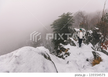 Man Tourist Hiking in Winter Mountain Landscape 135554573