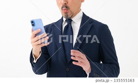 スマートフォンを持って驚くビジネスマン 135555163