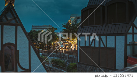 Twilight Cityscape with Half-Timbered Colonial Buildings Framing Bustling Street Scene Twilight Cityscape with Half-Timbered Colonial Buildings Framing Bustling Street Scene 135555473