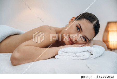 Conception of body care. Beautiful young woman lying on a couch in a spa salon Conception of body care. Beautiful young woman lying on a couch in a spa salon 135555638
