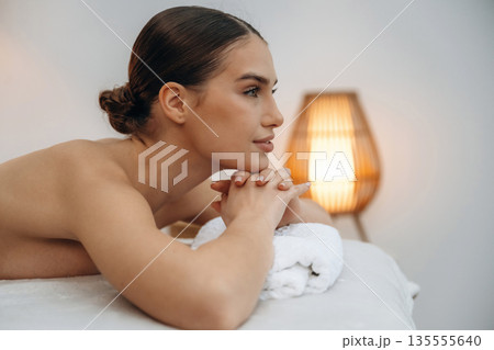 Conception of body care. Beautiful young woman lying on a couch in a spa salon Conception of body care. Beautiful young woman lying on a couch in a spa salon 135555640