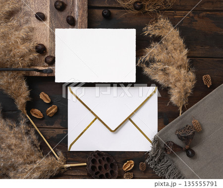 Card and envelope boho mockup on dark wood near natural decor and pampas grass top view Card and envelope boho mockup on dark wood near natural decor and pampas grass top view 135555791
