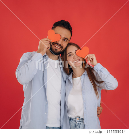Having fun with paper hearts. Lovely couple are together in the studio Having fun with paper hearts. Lovely couple are together in the studio 135555914