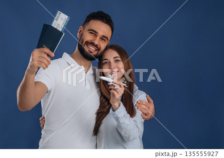 Standing and smiling. Couple are ready to travel, with tickets 135555927